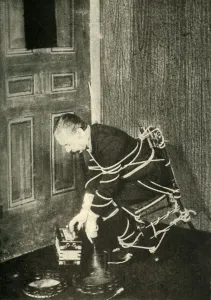 John Nevil Maskelyne performs a spirit cabinet illusion, c1910. Creator: Unknown