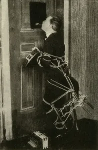 John Nevil Maskelyne performs a spirit cabinet illusion, c1910. Creator: Unknown