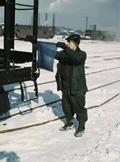 John Paulinski, car inspector, blue flagging a train for inspection, Corwith yard, Chicago, 1943. Creator: Jack Delano