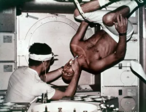 Dentist Prints: Kerwin examining Conrad on Skylab 2, 1973. Creator: NASA