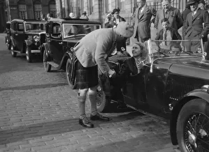 Kitty Brunell in her Aston Martin, chatting to a man in Highland dress, RSAC Scottish Rally, 1933