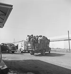 Labor contractors truck with gang of pea pickers pulled up for gas, Westley, California, 1939. Creator: Dorothea Lange