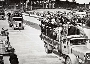 Construction Worker Gallery: Labourers salute Hitler from packed trucks on a Nazi-built road, 1936
