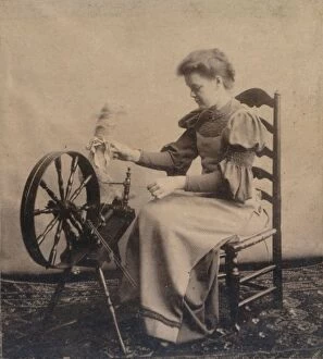 A lady at a spinning wheel c1900