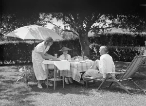Deck Chair Prints: Leonard, Mr. and Mrs. eating outdoors, between 1926 and 1938. Creator: Arnold Genthe