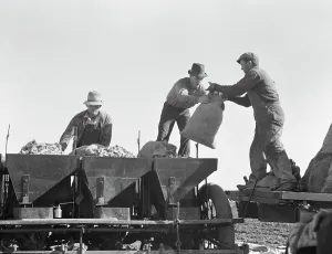 Seed Prints: Loading bins of potato planter which fertilizes and plants potatoes