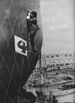 Inflated Collection: Making adjustments to the net of a balloon before attaching the basket, c1935 (c1937)
