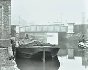 London County Council Collection: Man mooring a barge by a river bank, Poplar, London, 1905
