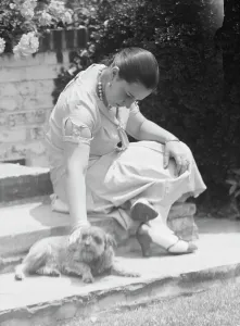 Artists Daughter Prints: Manship, Pauline, Miss, with dog, seated outdoors, 1931 June 14. Creator: Arnold Genthe