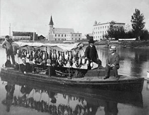 Position Collection: Marshall Erwin in front of a boat containing a kill of ducks, between c1900 and 1927