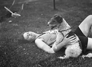 Lying On Back Prints: McKeogh, Arthur, Mrs. with dog, outdoors, 1927 Creator: Arnold Genthe