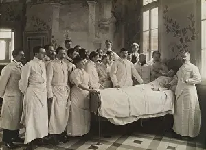 Patient Prints: Medical staff standing round a woman patient in bed in a hospital ward