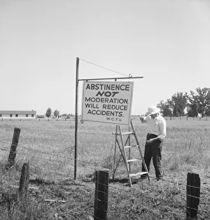 Member of the committee... erects sign on U.S. 99 highway, near Hanford, California, 1939. Creator: Dorothea Lange