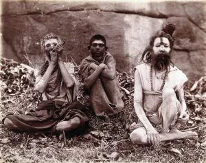 Mumbai Maharashtra India Prints: Two men and a boy sitting cross-legged on the ground surrounded by leaves; their faces