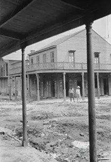 Unpaved Prints: Two men crossing an unpaved street