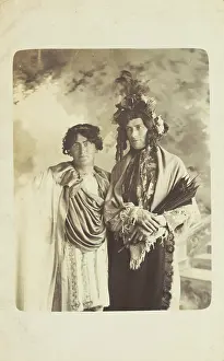 Plumed Prints: Two men in drag, one wearing a detailed feathered head garment