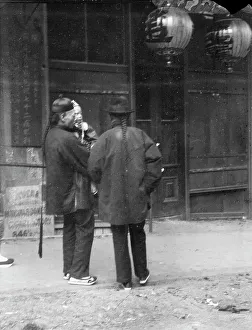 Two men, one holding a child, standing in the street, Chinatown, San Francisco, c1896-1906. Creator: Arnold Genthe
