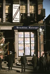 Headline Prints: Men reading headlines posted in street-corner of Brockton Enterprise