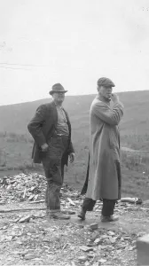 Settlers Prints: Two men standing near a small pile of rubble