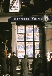 Slides Color Gmgpc Gallery: Men and a woman reading headlines posted in street-corner window of Brockton... Mass. 1940