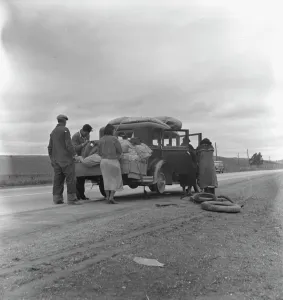 Immigration Prints: Migrants, family of Mexicans, on road with tire trouble