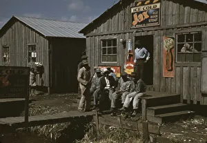 Sign Collection: Migratory laborers outside of a 'juke joint'during a slack season, Belle Glade, Fla. 1941