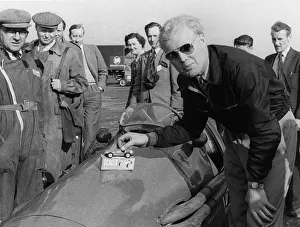 Hawthorn Prints: Mike Hawthorn admiring a toy model Ferrari on his racing Ferrari. Creator: Unknown