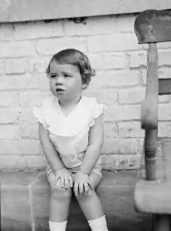 Moseley, F.S. Mr. child of, seated outdoors, 1930 May 24. Creator: Arnold Genthe