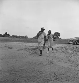 Mother of sharecropper family and friend... in the rain, Person County, North Carolina, 1939. Creator: Dorothea Lange