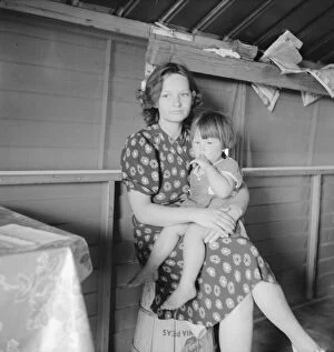 Refugee Gallery: Mother with sick baby awaits arrival of FSA camp resident nurse, FSA camp, Tulare County, CA, 1939