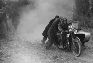 Sidecar Prints: Motorcycle and sidecar receiving a push during a trial, c1930s. Artist: Bill Brunell