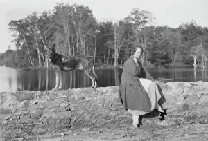 Stone Wall Prints: Mower, Margaret, Miss, with dog, seated outdoors, not before 1916. Creator: Arnold Genthe