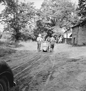 Mr. Taylor and wage laborer slide tobacco... Granville County, North Carolina, 1939. Creator: Dorothea Lange