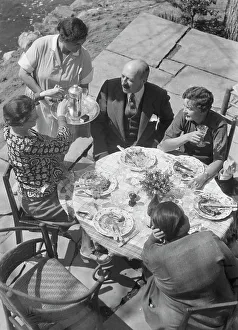 Luncheon Prints: Mrs. Mary Benson and other people seated outdoors, 1933. Creator: Arnold Genthe