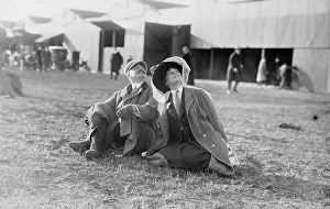 Landing Ground Prints: Mrs. Payne Whitney with unidentified gentleman seated on flying field of aviation meet