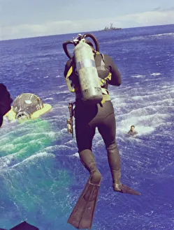 Recovery Prints: Navy diver leaps from helicopter, 1965. Creator: NASA