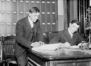 Paperwork Prints: Two new citizens sign naturalizaton papers in judge's chambers