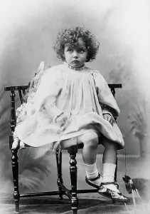 Nora Schuster aged 3, seated, facing forwards, c1895. Creator: Mrs Fred Wilkinson
