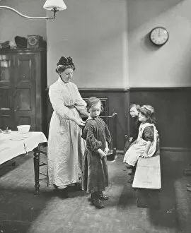 Guildhall Library Art Gallery: Nurse examining children before cleansing, Chaucer Cleansing Station, London, 1911