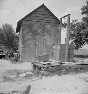 The Carolinas Prints: Well and old plantation smokehouse, Chesnee, South Carolina, 1937. Creator: Dorothea Lange