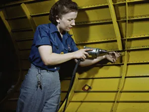 Operating a hand drill at Vultee-Nashville, woman is working on a Vengeance'dive... Tenn. 1943. Creator: Alfred T Palmer
