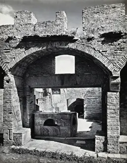 Partly ruined buildings in Ostia identified as a tavern or hot-food shop (thermopolium)... 1920-9. Creator: Domenico Anderson