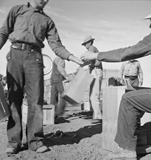 Straw Hat Collection: Paymaster on edge of pea fields pays a... near Calipatria, Imperial Valley, CA, 1939