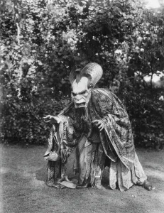 Person wearing a mask made by W.T. Benda, 1925 Sept. 20. Creator: Arnold Genthe