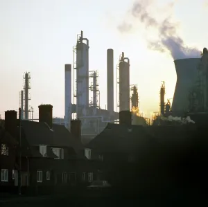 A petrochemical plant towering over residential housing, Baglan Bay, Wales, 1975