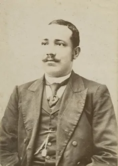 Photograph of a man wearing a dark colored suit with a pocket watch in his vest