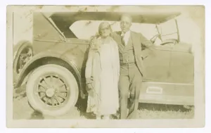 Portraits Gallery: Photograph of a man and woman in front of car, ca. 1921. Creator: Unknown