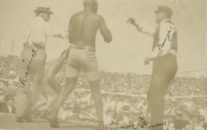 Referee Prints: Photographic postcard of James J. Jeffries staggering away from Jack Johnson, 1910