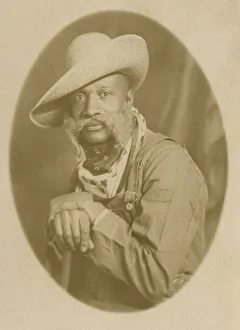 Portraits Prints: Photographic postcard portrait of a man wearing a hat and overalls, early 20th century