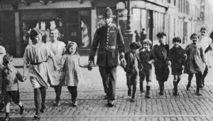 Road Safety Prints: Policeman helping schoolchildren across the road, East End, London, 1926-1927